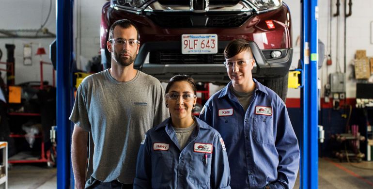 2 females and 1 male car mechanic in an auto repair shop
