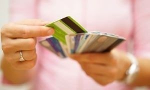 Picture of someone's hands holding multiple credit cards.