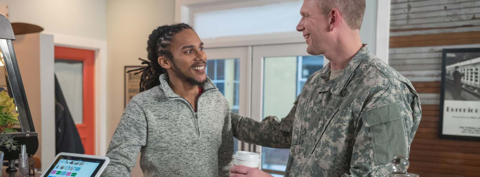 Man in uniform extends a welcome to another man.