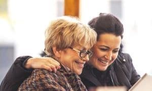 Mother with adult daughter smiling