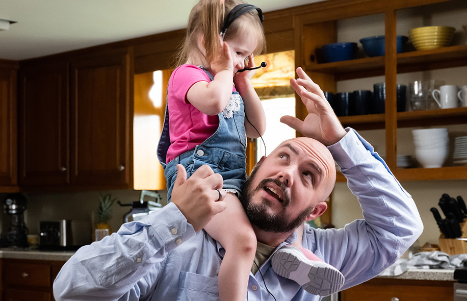 Florence Bank Community Videos - A man works from home with his daughter sitting on his shoulders