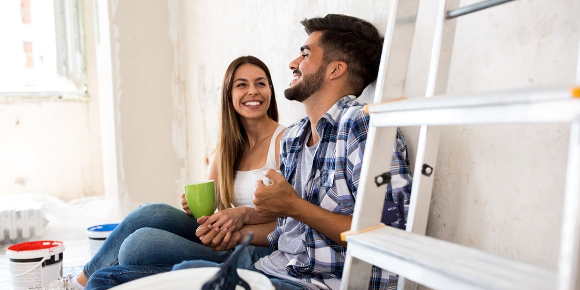 Happy young couple sitting on floor of new home