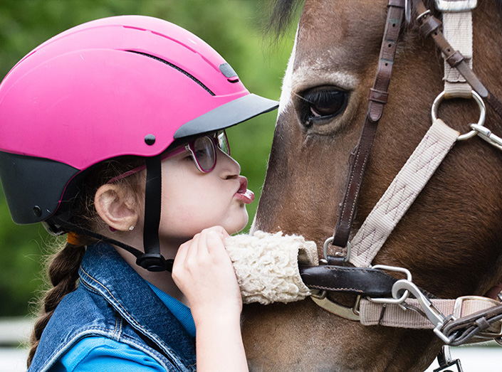 A girl kisses a horse's face