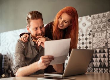Couple smiling looking at paper