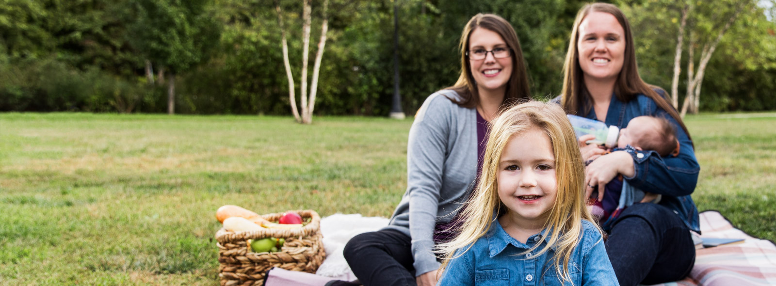 Young family enjoy outdoor picnic in a park.