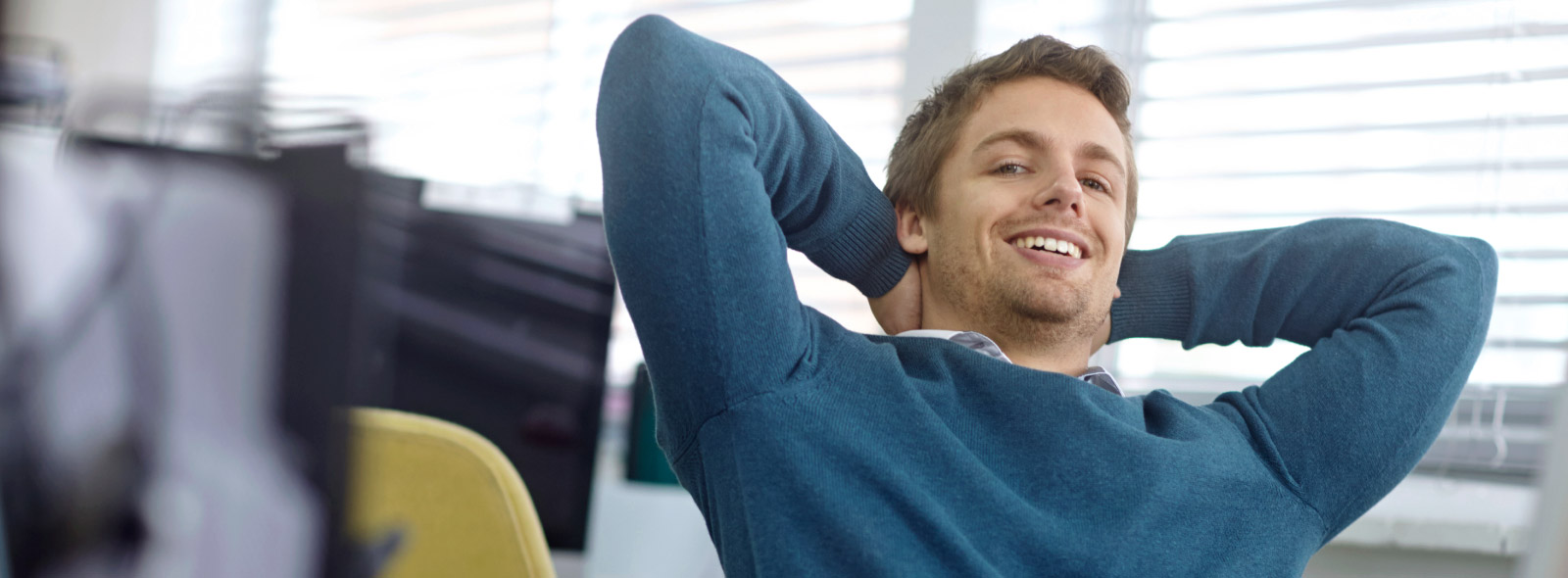 Confident man sitting back in is office chair.