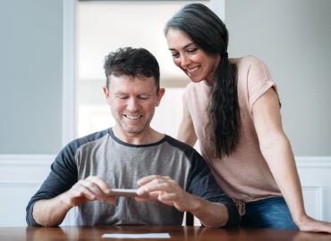 Man going through Mobile Deposit Process while woman looks on.