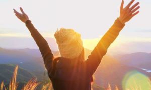 Woman with hands raised in a mountain setting