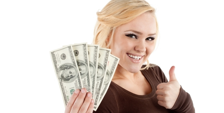 Teen holding cash and giving the thumbs up sign