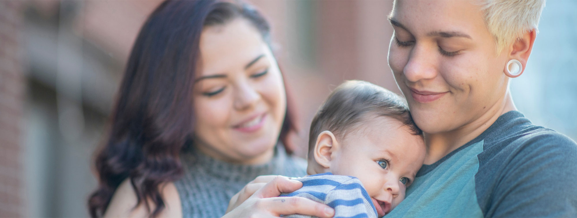 Happy young family holding a baby